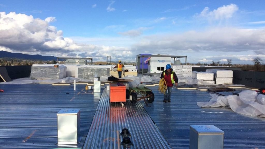 Commercial roofing contractors installing flat metal roof in NYC