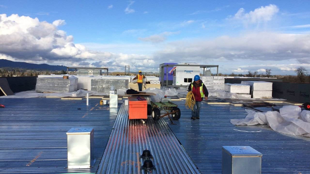 Commercial roofing contractors installing flat metal roof in NYC