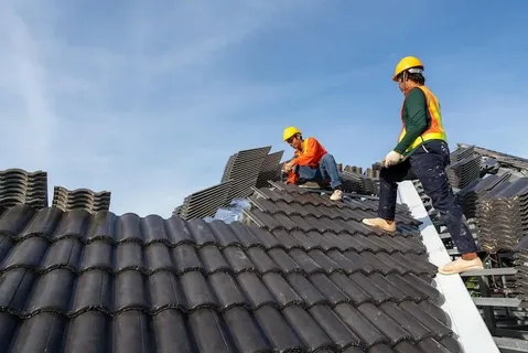 Roofers installing ceramic roof tiles