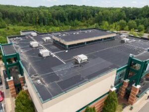 Commercial roofing contractor installing TPO membrane on flat roof in New York City