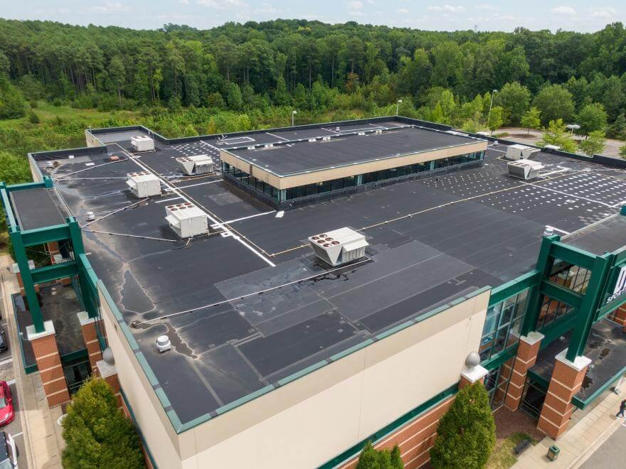 Commercial roofing contractor installing TPO membrane on flat roof in New York City